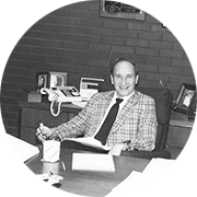 Black and white image of a businessman sitting in a chair at a desk