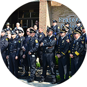 Group of uniformed police officers standing in front of a brick building